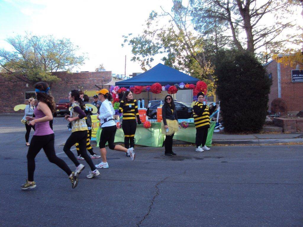 People running and several volunteers dressed in bee costumes for Day of the Tread